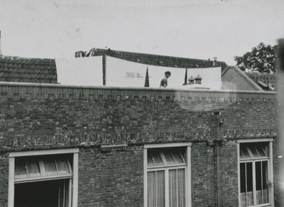 874836 Afbeelding van het dienstmeisje van de familie Van Doesum, dat de was opgehangt op het dak van het pand ...